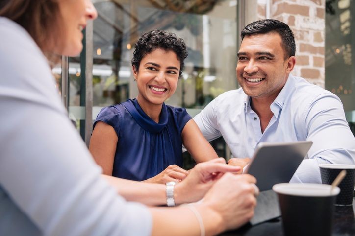 two people sitting front a third person giving them advise